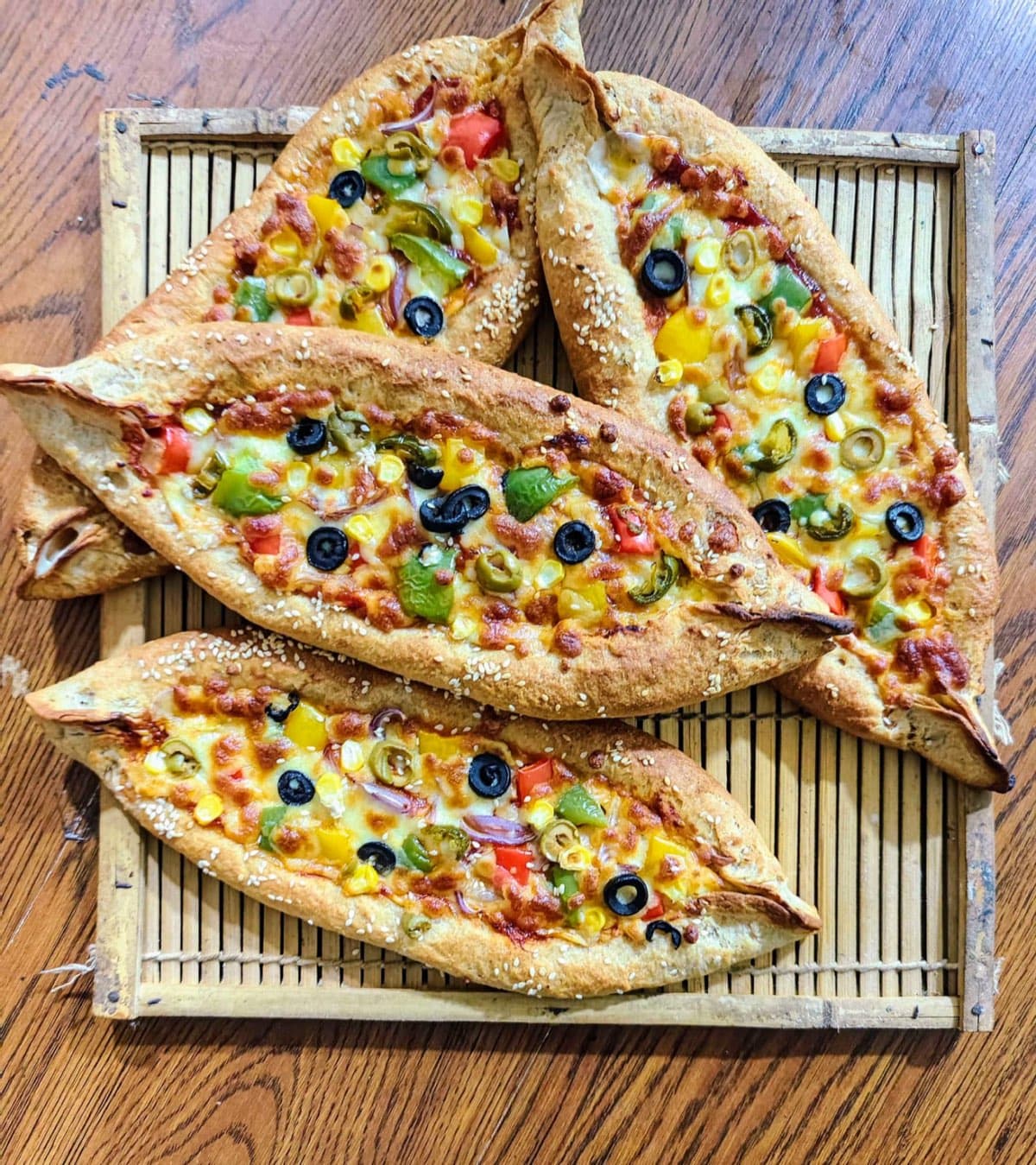 Millet-based pide flatbreads with peppers, olives and cheese